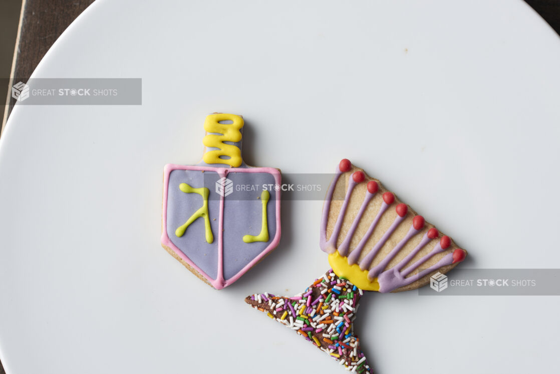 Two decorated Hanukkah cookies on a white plate, close-up