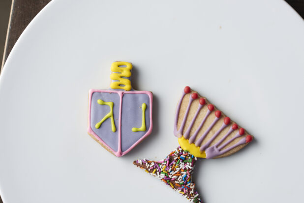 Two decorated Hanukkah cookies on a white plate, close-up