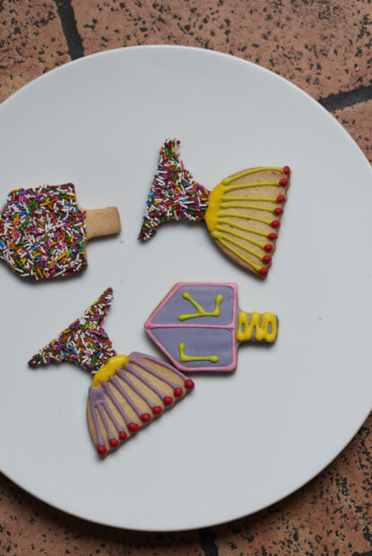 Four decorated Hanukkah cookies on a white plate