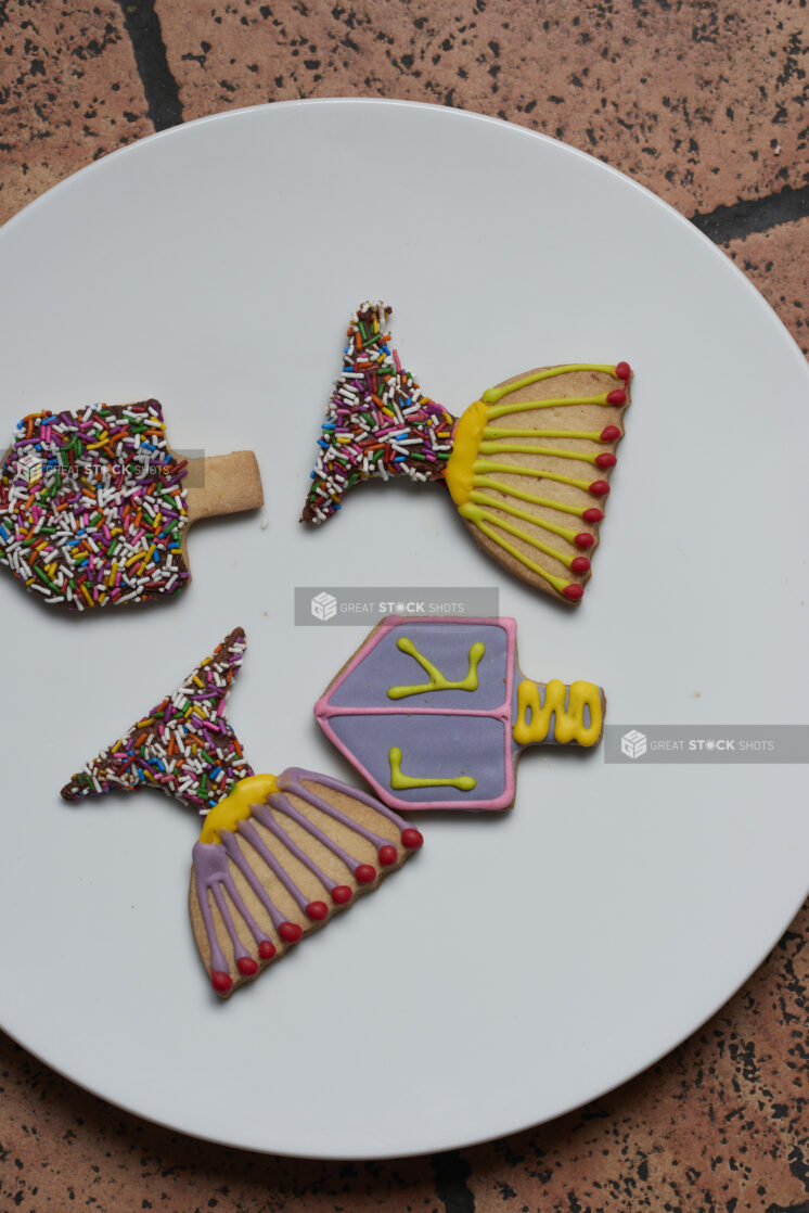 Four decorated Hanukkah cookies on a white plate