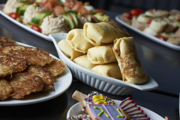 A buffet of blintzes, latkes, and assorted plates for Hanukkah