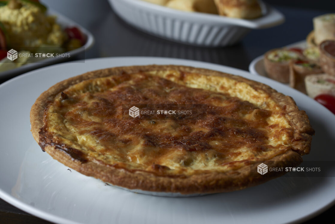 A savoury pie on a buffet with other assorted plates