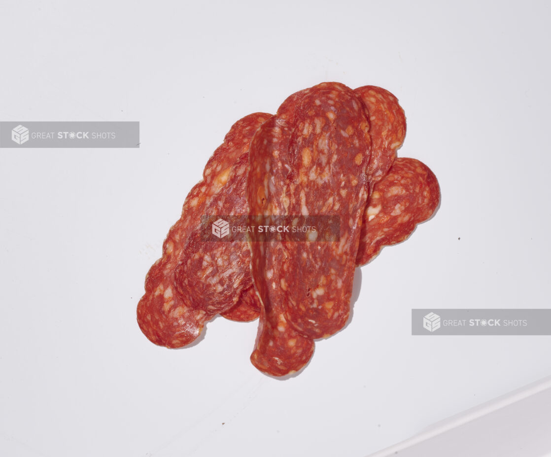 Sliced soppressata on a white background