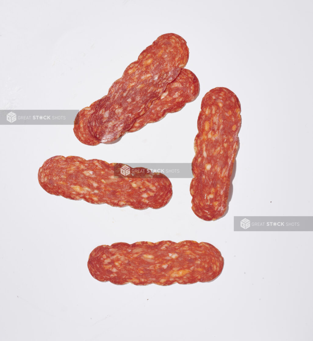 Sliced soppressata salami on a white background