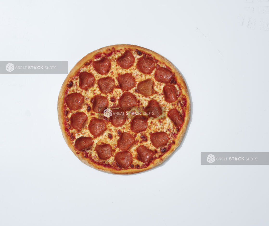 Whole unsliced Brooklyn style pepperoni pizza on a white background