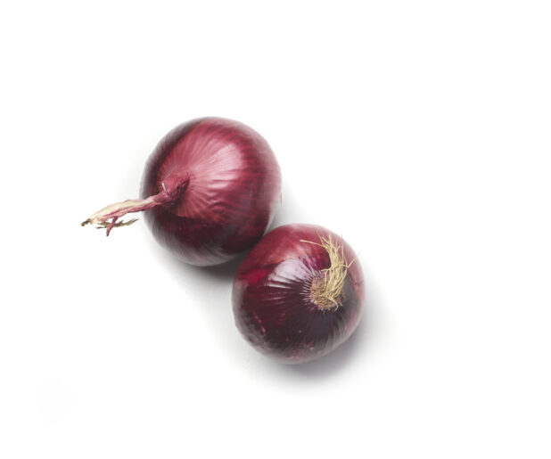 Whole red onions on a white background