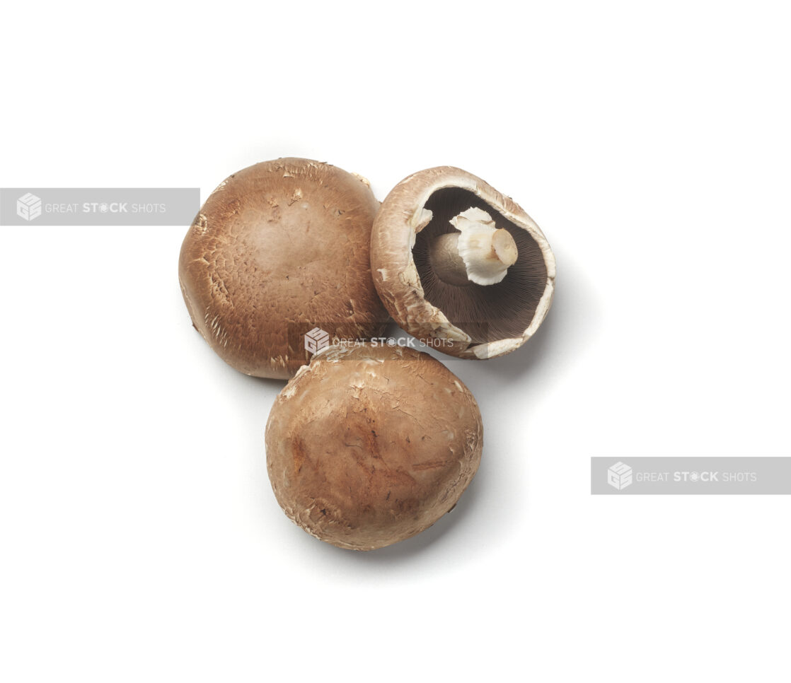 Whole cremini mushrooms on a white background