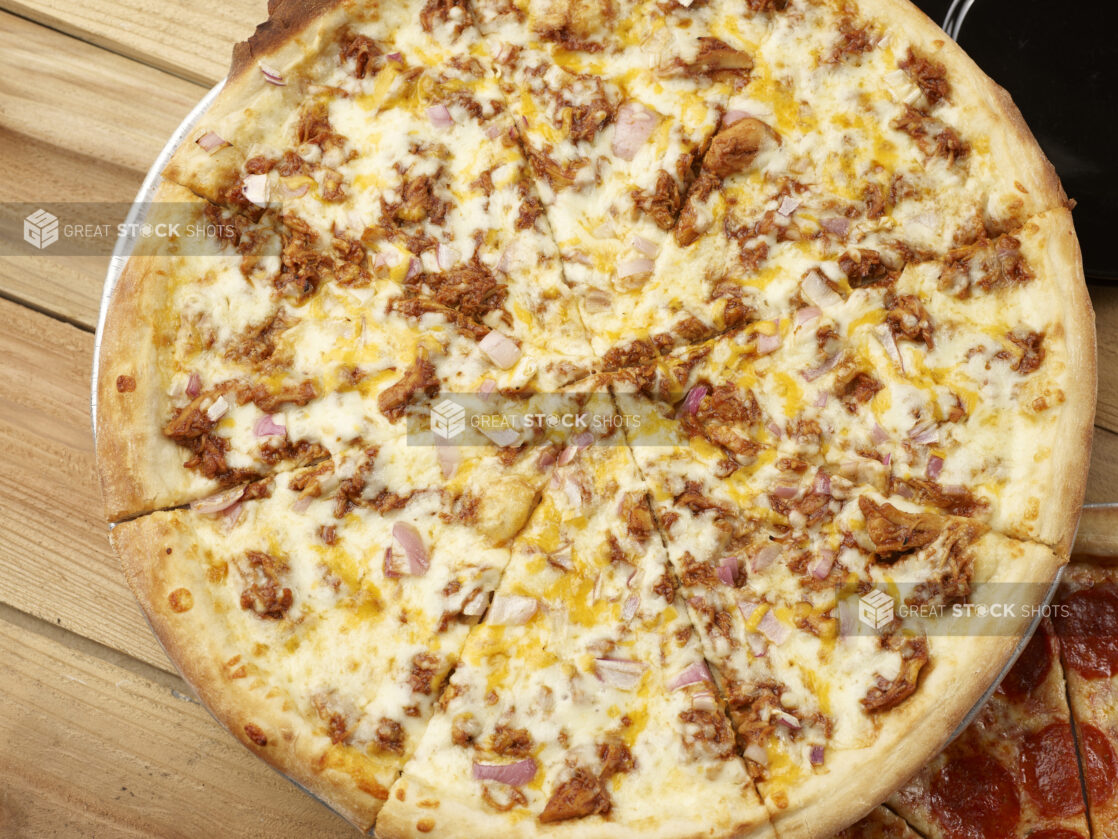 Whole sliced 2 topping pizza with pulled pork and red onions, overhead view