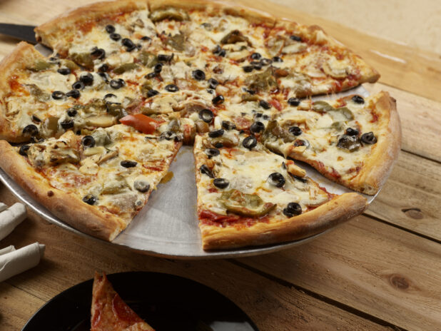Whole sliced 3 topping pizza with black olives, roasted bell peppers and mushrooms