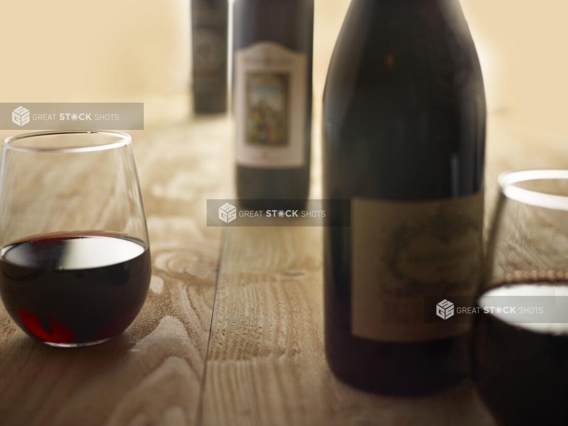 Bottles of Red wine with 2 glass of red wine on a wooden background