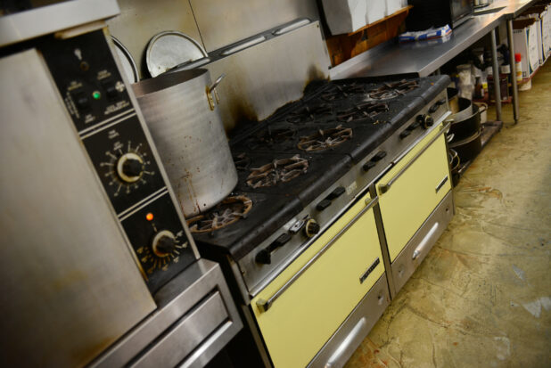 Commercial/restaurant kitchen, view of gas range, ovens, prep table