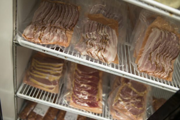 Butcher wrapped and vacuum sealed bacon in a refrigerator, English bacon, Canadian bacon