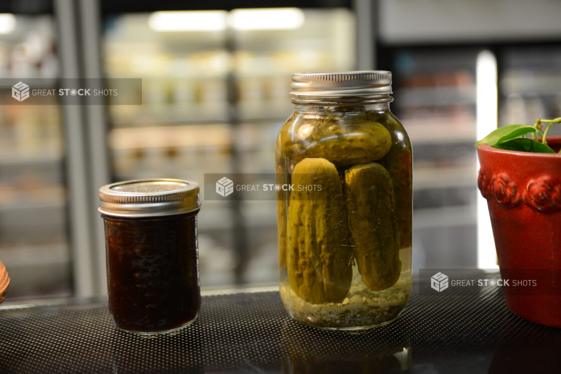 Mason jars of pickles and preserves in a grocery store setting