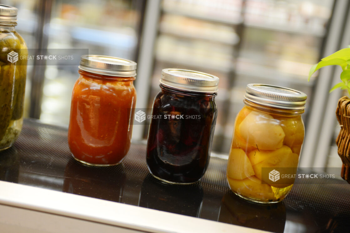 Mason jars of preserves in a grocery store setting