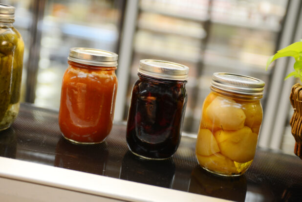 Mason jars of preserves in a grocery store setting