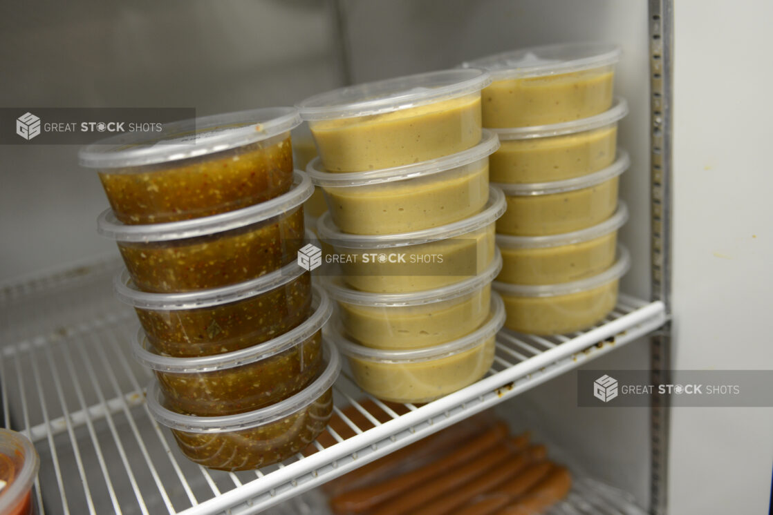 Dips and dressings in 8oz (250ml) clear plastic containers, stacked in a refrigerator