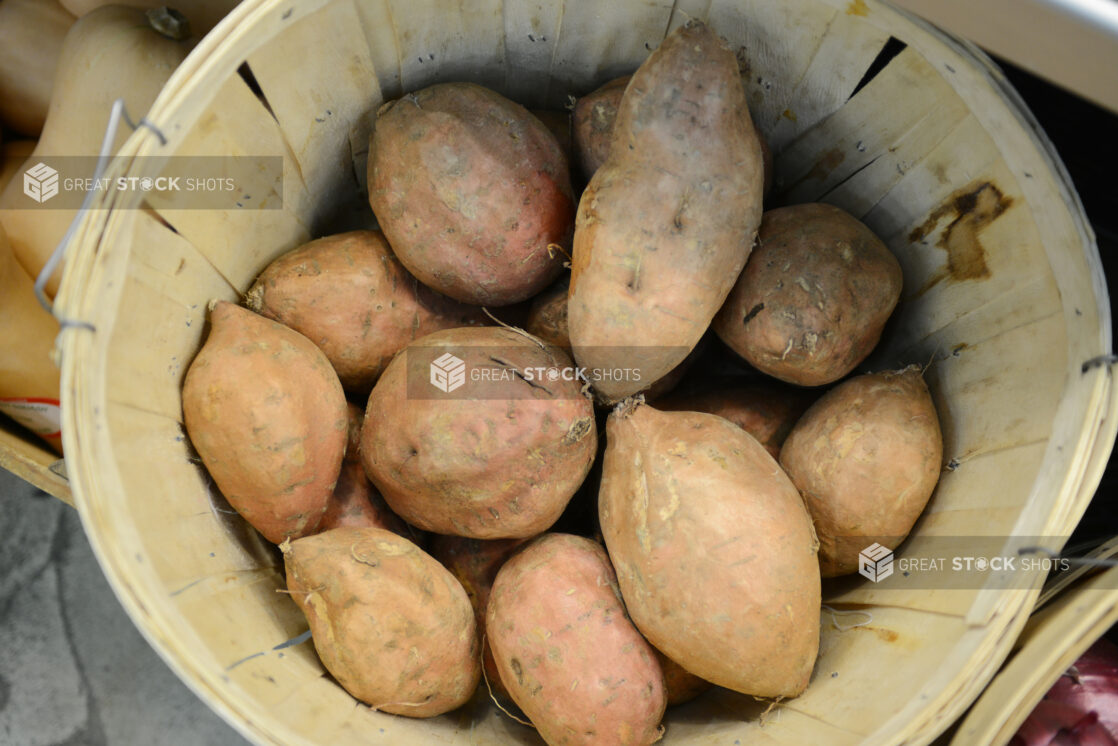 Whole sweet potatoes in a bushel basket, overhead view