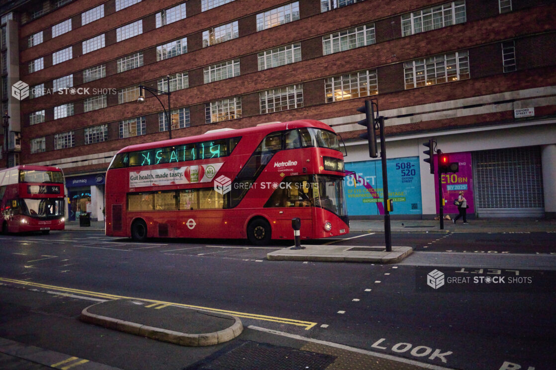 2 double decker buses on a street in London, England