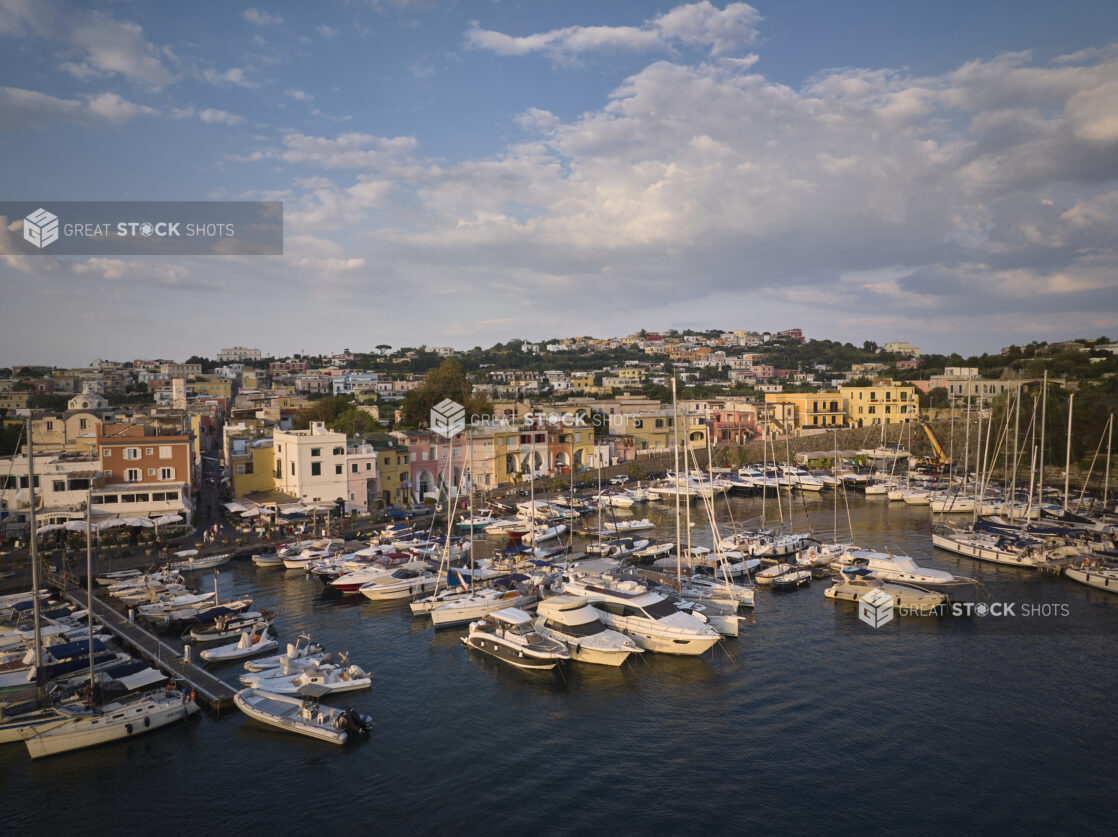 View of a marina with a town and hillside in Italy