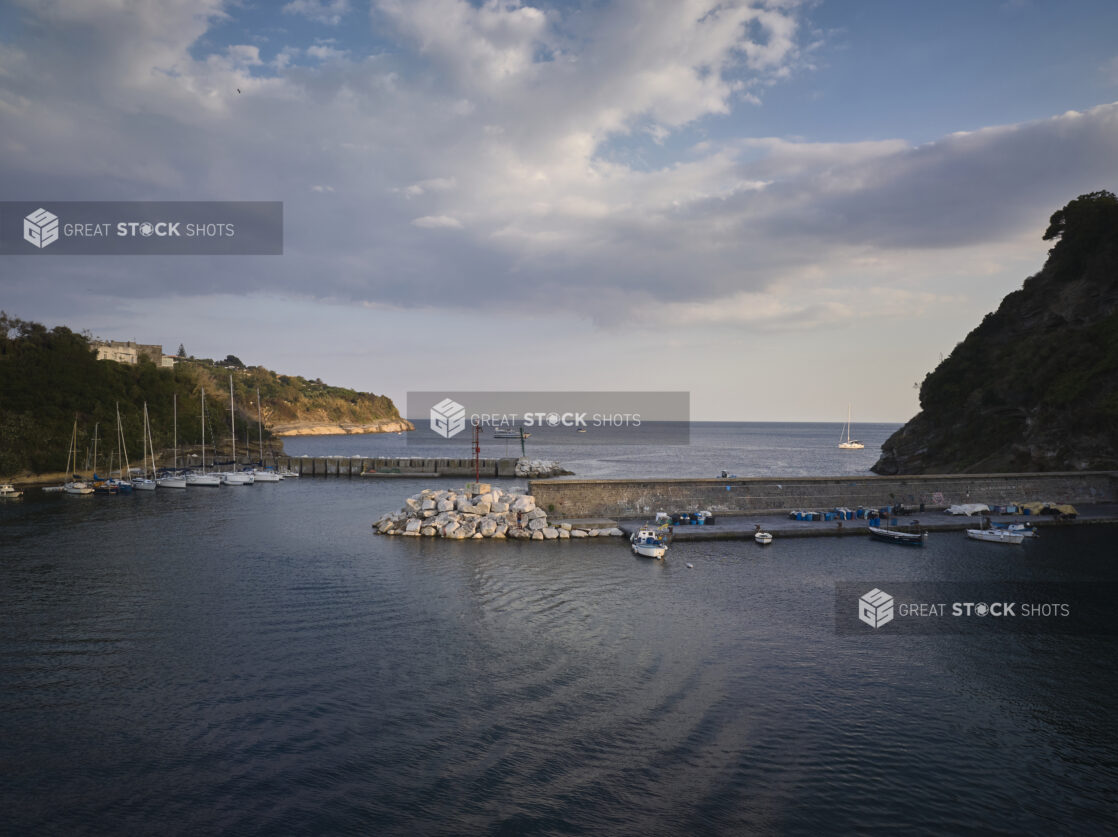 Sunset/sunrise view of a hills, marina, and outer harbour in Italy