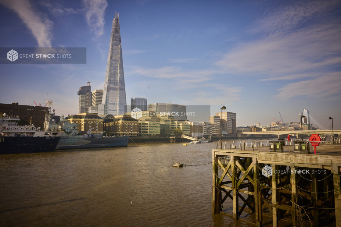 Medium wide shot of the Thames River in London with The Shard Building in background