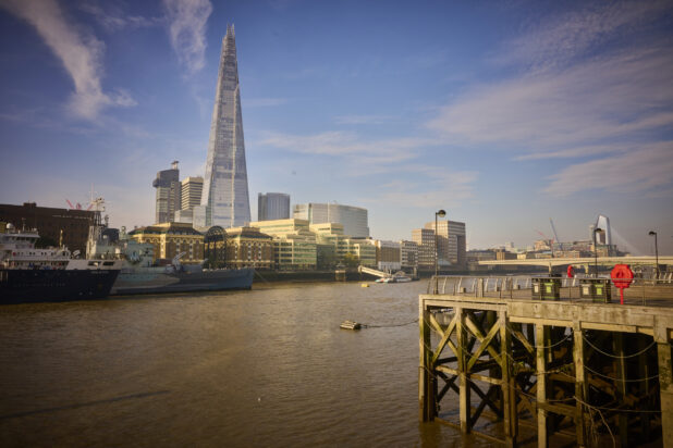 Medium wide shot of the Thames River in London with The Shard Building in background