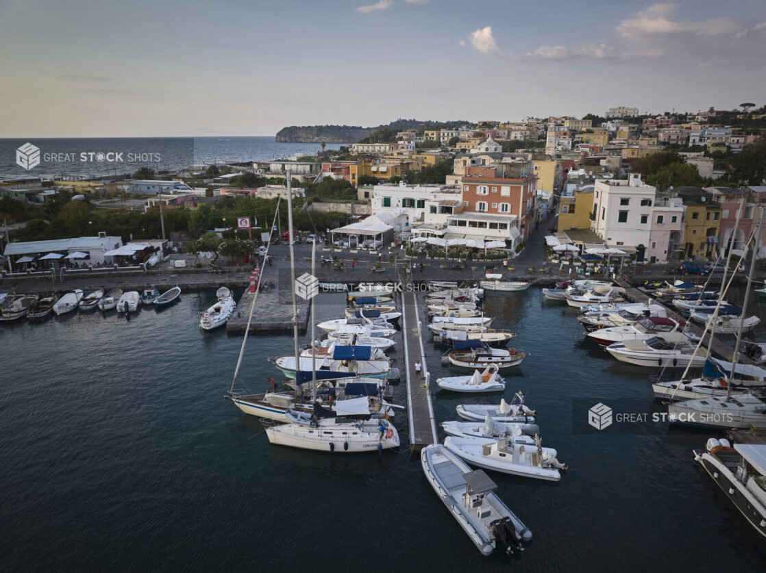 View of a marina with a town and hillside in Italy