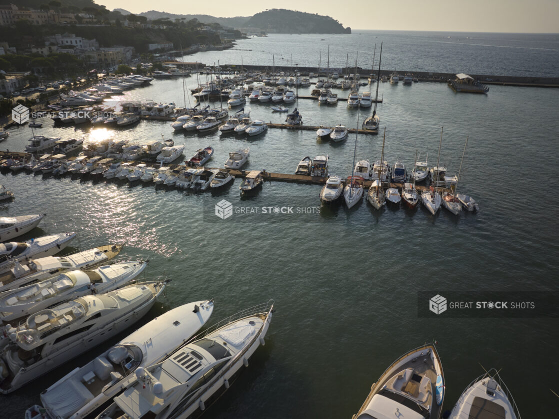 Sunrise/sunset view of a marina, town and hillside in Italy