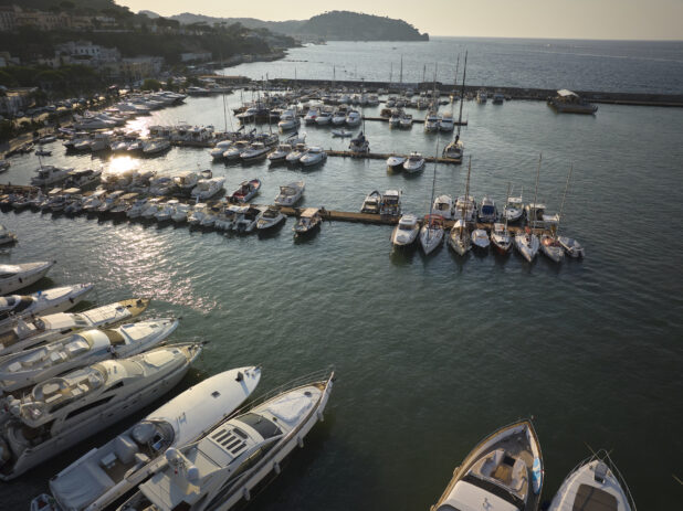 Sunrise/sunset view of a marina, town and hillside in Italy
