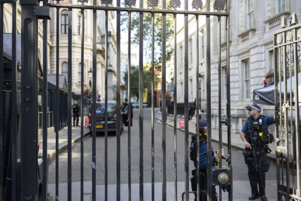 London Police standing by a wrought iron gate at 10 Downing street