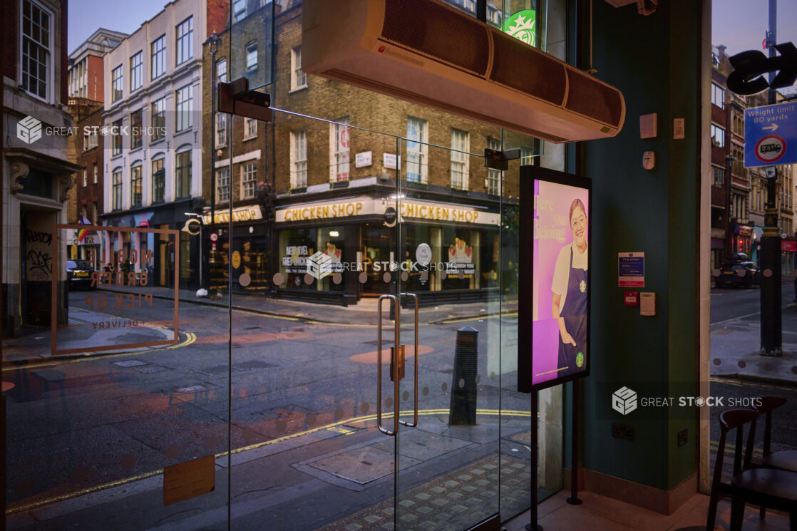 Street view of shops in London, England, from inside a shop with glass doors and windows