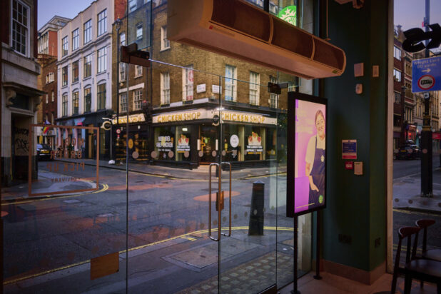 Street view of shops in London, England, from inside a shop with glass doors and windows