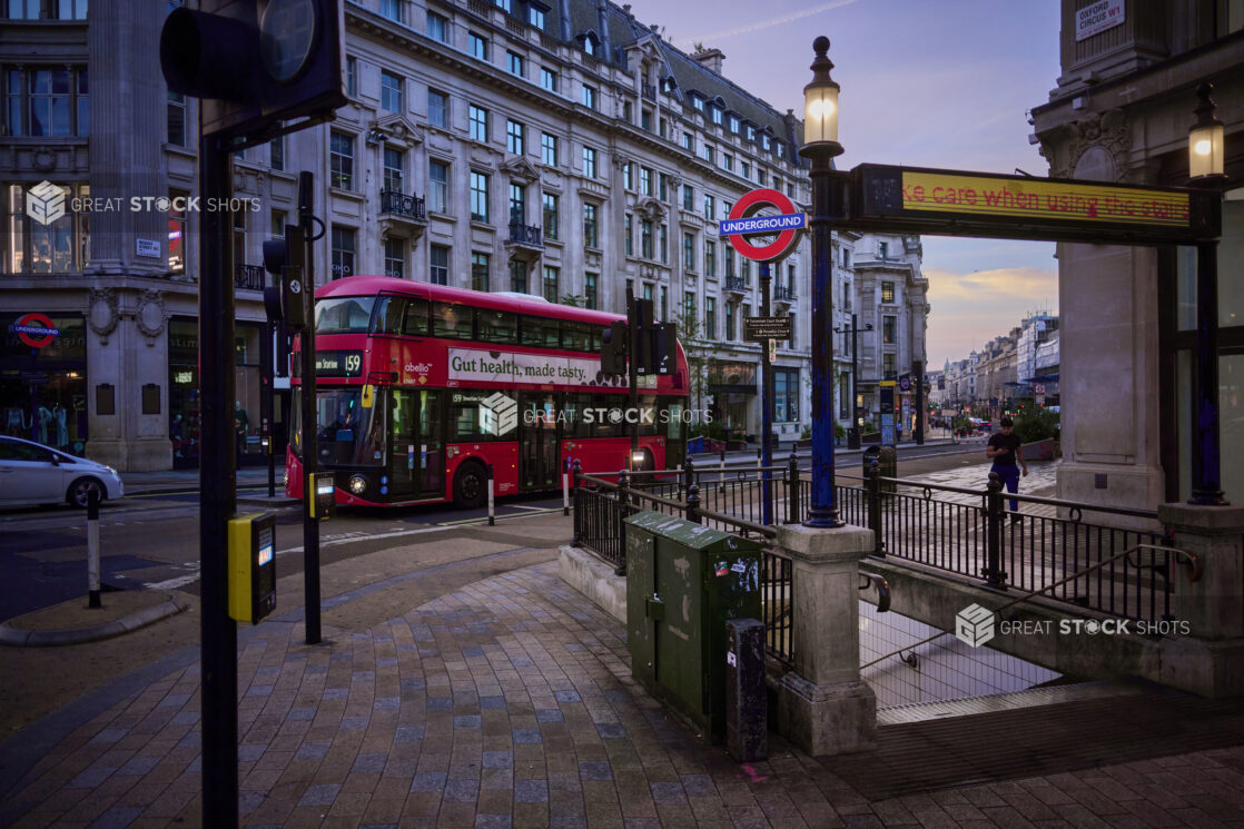 View of a tube (subway) station entrance with a double decker bus on the road and "Underground" street signs