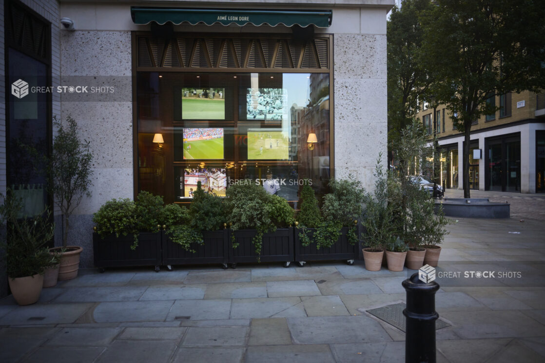 Outside view of a sports bar interior, street view, planters surrounding