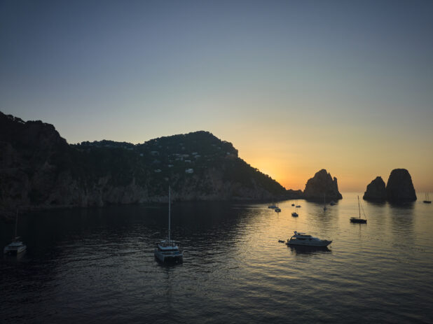 Sunrise/sunset view of the Faraglioni rock formation in Italy