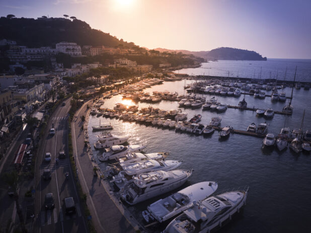 Sunrise/Sunset view of a marina, roadway a and town in Italy