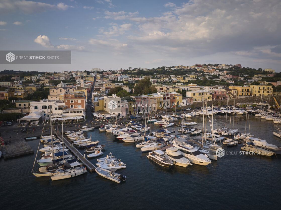 View of a marina with a town and hillside in Italy