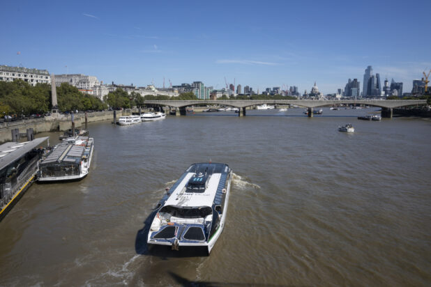 An Uber Boat and Other Tourist Boats Floating on the River Thames in London, England