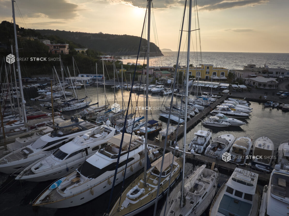 Overhead view of a marina with yachts and boats on a coastline in Italy at sunrise/sunset