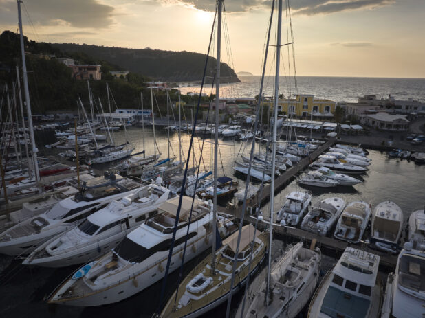 Overhead view of a marina with yachts and boats on a coastline in Italy at sunrise/sunset