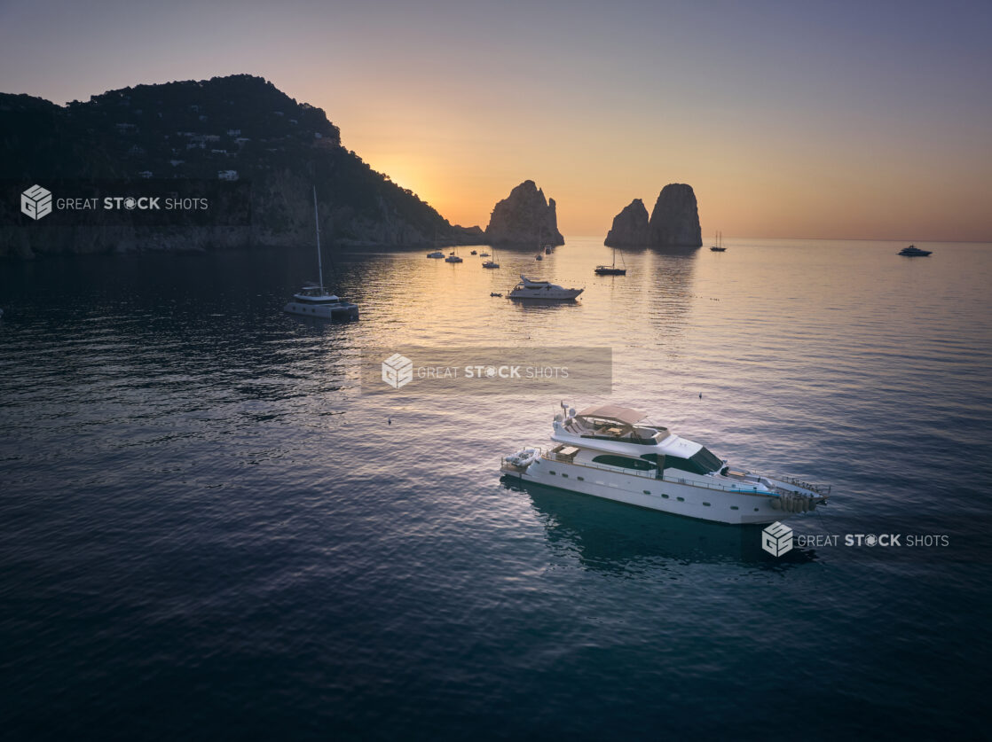 Sunrise/sunset views of the coastline in Capri, Italy, with yachts and hillside