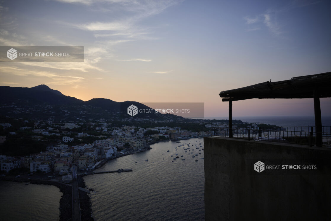 Sunset Dusk Wide Landscape Portrait of Italian Costal Town with Mountains in ground, boats in harbour and a colourful sky