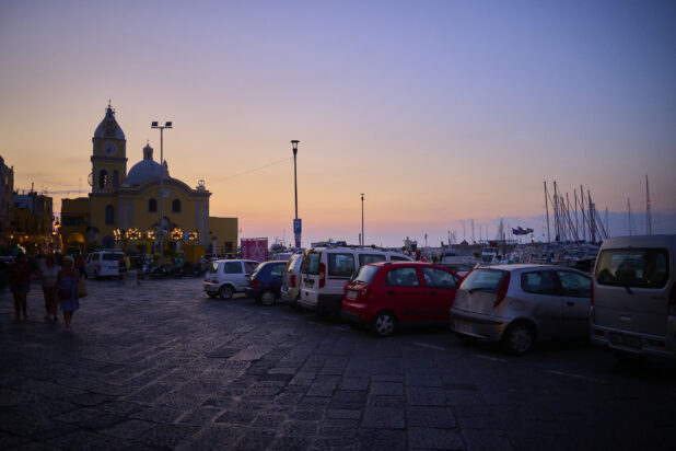 Parking lot of Italian Coast Harbour or Marina at Sunset with a building in the background