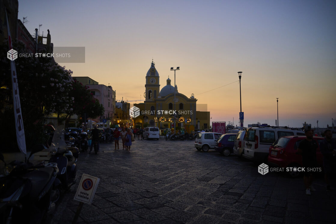 Wide shot of Parking lot of Italian Coast Harbour or Marina at Sunset with a building in the background