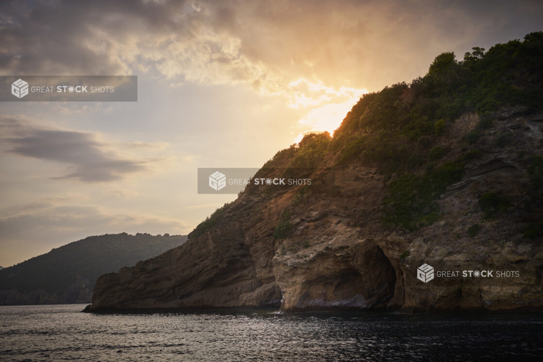 Sun Setting Behind Rocky Mountain Cliffs on an Italian Coastline