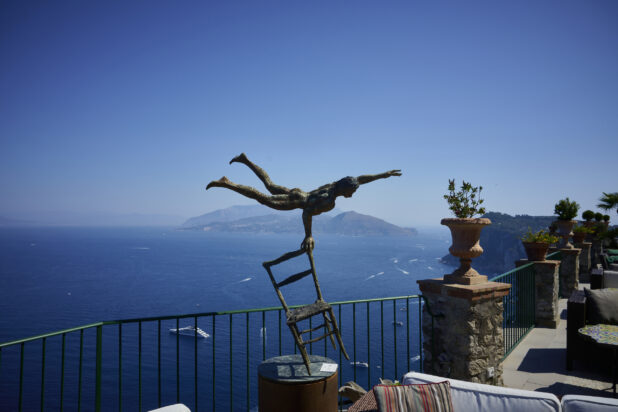 Bronze Art Statue on Outdoor Terrace overlooking Italian Coastline with beautiful Cliffs in the background surrounded by perfectly blue ocean