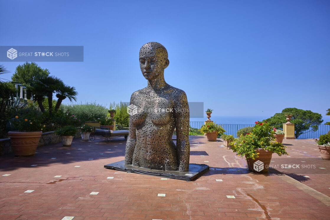 "Meditation 1039" by Seo Young Deok on a brick walkway in Capri, Italy, flowers and the Mediterranean sea in the background