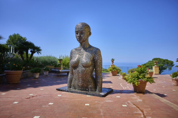 "Meditation 1039" by Seo Young Deok on a brick walkway in Capri, Italy, flowers and the Mediterranean sea in the background
