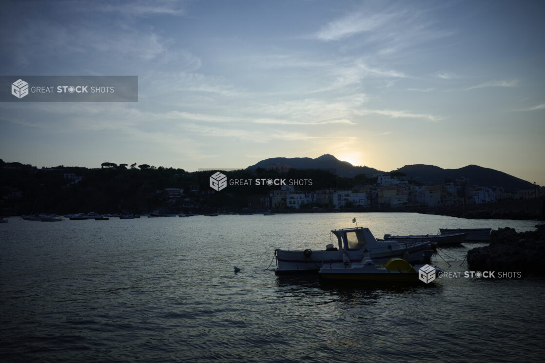 Small Boat floating on Ocean in harbour of Italian Coast at sunset