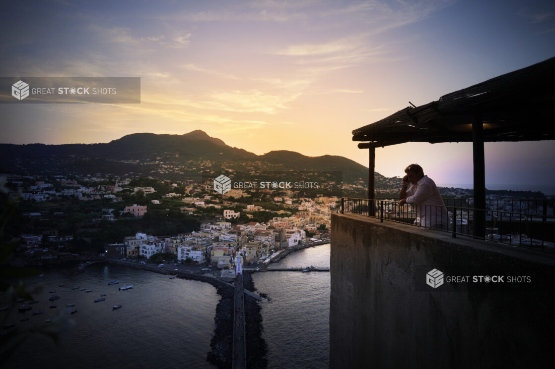 Sunset Dusk Wide Landscape Portrait of Ischia, Italian Costal Town with Mountains in ground, boats in harbour and a colourful sky